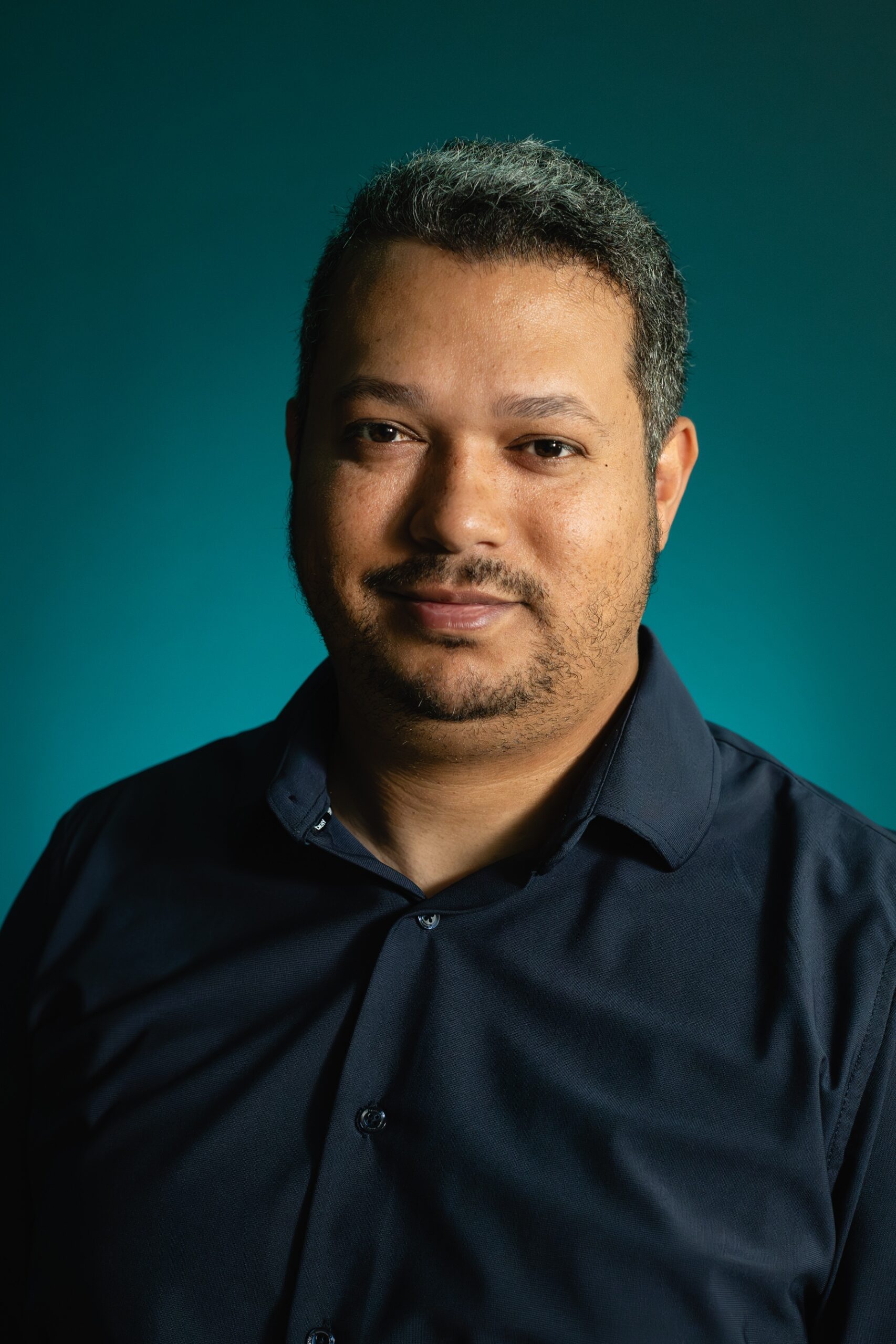 Portrait of Rodrigo Chaves against a teal background
